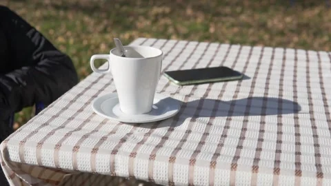 The tablecloth on the table with a porridge of tea and a mobile phone develops Video stock 162953372