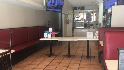 Tables act as a barrier inside a Toronto restaurant as news for COVID19 plays on Stock Footage 127852791