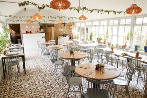 Tables and chairs in an empty restaurant in bright daylight Stockfoto's