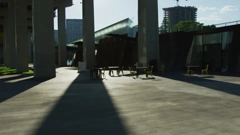 Tables and chairs under a bridge Stockbeeldmateriaal 218087372
