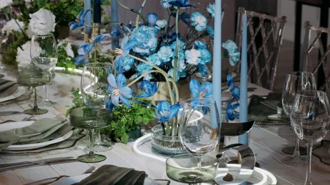  tables in a restaurant declared with blue flowers Stock Footage 276473336