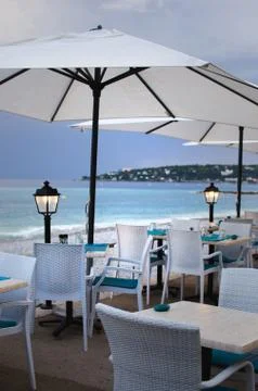 Tables for a romantic meal on the beach with lanterns and chairs. With sunset Stock Photos