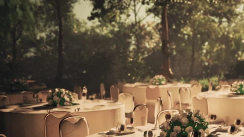 Tables set for dinner in an outdoor location with plants and flowers Stock Footage 344381608