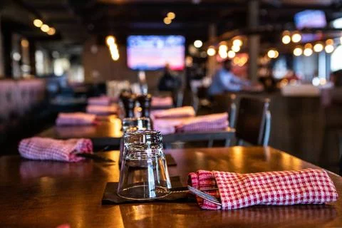 Tables set for evening service in pub. A close up view of glasses and dinn... Stock Photos