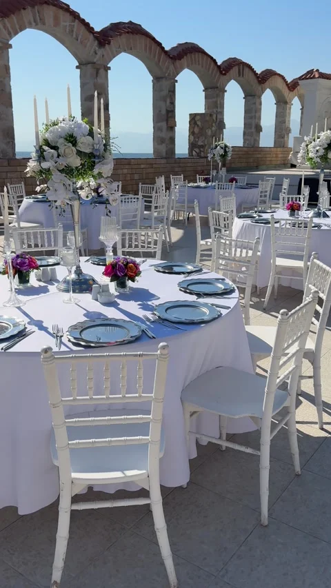 Tables set with fine dining utensils and decorations, prepared for a seaside  Stock Footage 301850090
