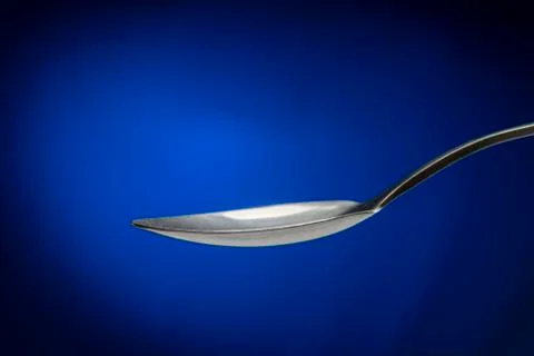 Tablespoon on blue background closeup Stock Photos
