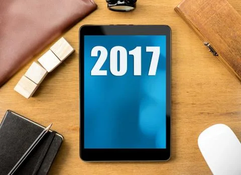 Tablet with 2017 year number on screen on wood desktop,Digital happy new year Stock Photos