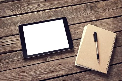 Tablet and notepad on desktop Stock Photos