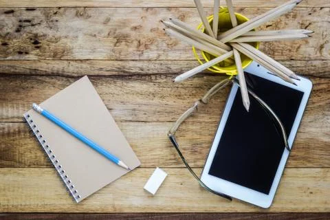 Tablet and notepad on wood table Stock Photos