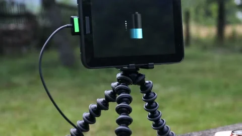 Tablet and smartwatch is charging from wireless power bank on the bench. Stock Footage 157875992