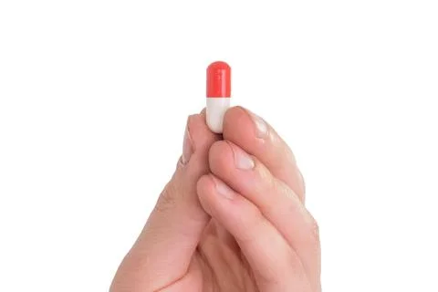 Tablet capsule is held in the hand with your fingers Stock Photos