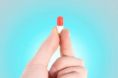 Tablet capsule is held in the hand with your fingers Stock Photos
