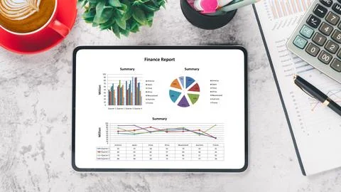 Tablet with charts and reports on office desk workplace. Top view flat lay Stock Photos