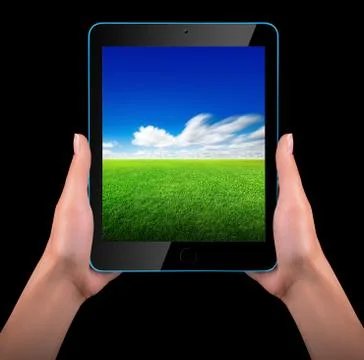 Tablet computer with blue sky and green grass Stock Photos