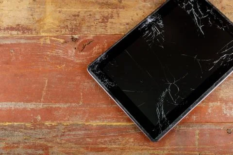 Tablet computer with broken glass screen on the wood background Stock Photos
