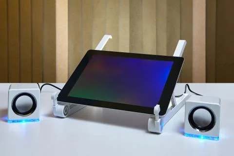 Tablet computer is connected to portable external speakers. Stock Photos