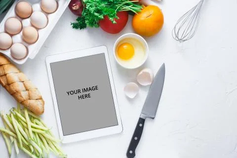 Tablet computer with fresh vegetables on white background, copy space Stock Photos