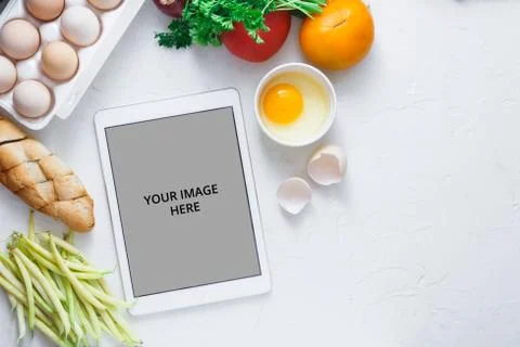 Tablet computer with fresh vegetables on white background, copy space Stock Photos