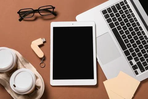 Tablet computer with laptop, takeaway cups of coffee, USB flash drive and eye Stock Photos