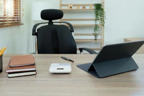 Tablet computer, notebook, calculator and coffee cup on the desk in the office Stock Photos