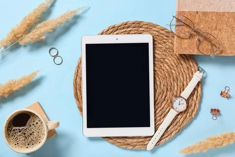 Tablet computer with notebook, wristwatch, cup of coffee and eyeglasses on bl Stock Photos