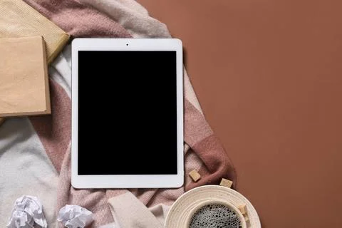 Tablet computer with notebooks, crumpled paper and cup of coffee on brown bac Stock Photos
