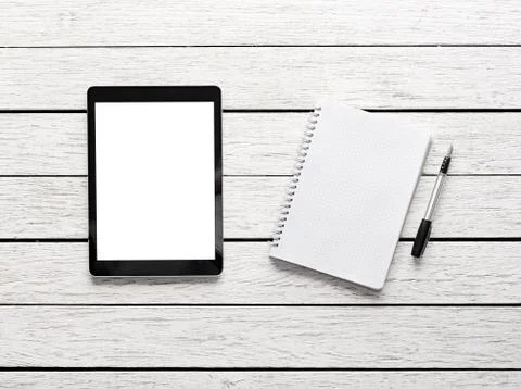 Tablet computer with notepad on desk 写真素材