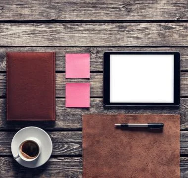 Tablet computer with notes and coffee cup on wooden desk. Clipping path Stock Photos