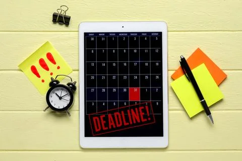 Tablet computer with open calendar, word DEADLINE, alarm clock and sticky not Stock Photos