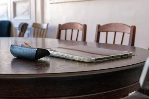 Tablet computer in protective case resting on a wooden dining table. Portab.. Stock Photos