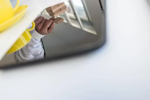 Tablet computer with reflection of a businessman building a tower of wood blo Stockfoto's
