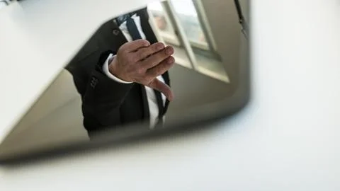 Tablet computer with reflection of businessman hand reached out to handshake Stockfoto's