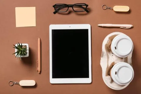 Tablet computer with takeaway cups of coffee, USB flash drives and eyeglasses Stock Photos