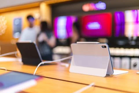 Tablet Computers on Wooden Display Table with Blurred Shoppers Foto stock