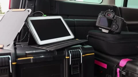 Tablet connected to portable solar panel, car interior with photo equipment. Stock Footage 157652507