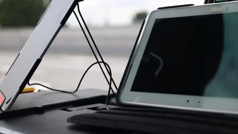 Tablet connected to portable solar panel, car interior with photo equipment. Stock Footage 157652510