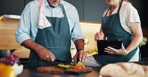 Tablet, couple cooking and hands cut vegetables in kitchen with online tutorial Stock Photos