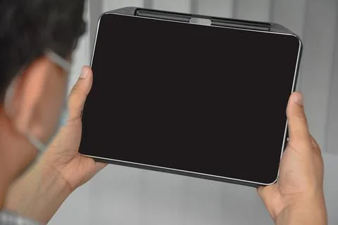 Tablet with dark blank screen holding in hands Stock Photos