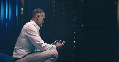 Tablet, developer and technician or man in server room for cyber security Stock Photos