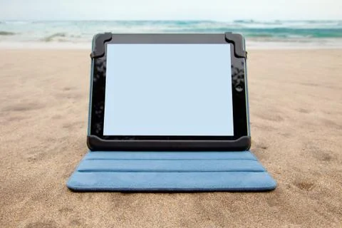 Tablet device on beach Stock Photos