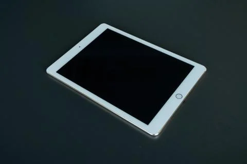 Tablet device, black screen on gray background Stock Photos