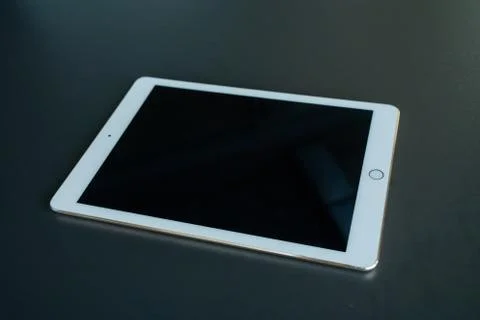 Tablet device, black screen on gray background Stock Photos