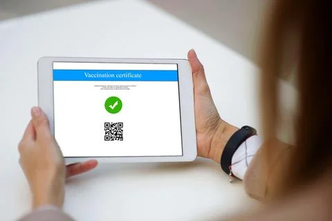 The tablet displaying a valid digital vaccination certificate passport for CO Stock Photos
