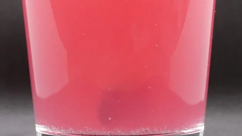 Tablet dissolving in water turning pink Stock Footage 252557740