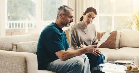 Tablet, documents and couple on sofa in home with planning budget, savings or Stock-Fotos