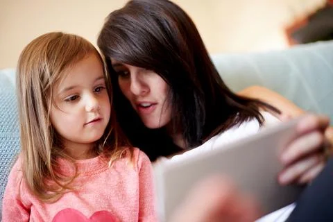 Tablet, elearning and mother with kid on sofa in living room for interactive Stock Photos