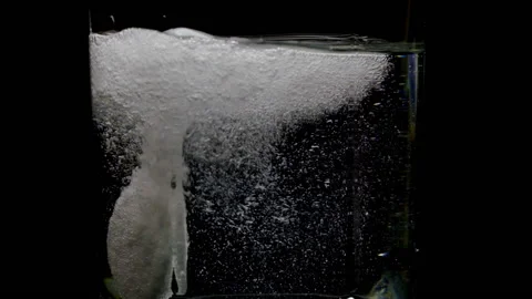 Tablet is falling and sparkling in a glass of water on the black background Stock Footage 166096470