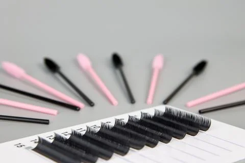 A tablet with false eyelashes and brushes on a black background. Stock Photos