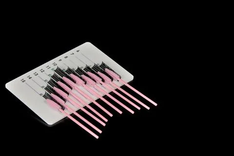 A tablet with false eyelashes and brushes on a black background. Stock Photos