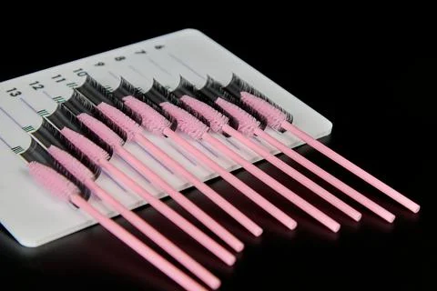 A tablet with false eyelashes and brushes on a black background. Stock Photos